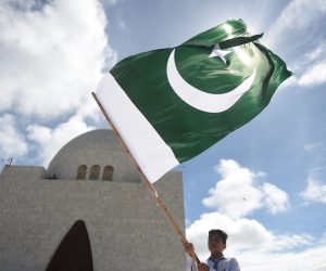 TOPSHOT - A student waves the national flag of Pakistan outside the mausoleum of country's founder Mohammad Ali Jinnah, after Pakistan's 75th Independence Day ceremony in Karachi on August 14, 2022. (Photo by Rizwan TABASSUM / AFP) (Photo by RIZWAN TABASSUM/AFP via Getty Images)